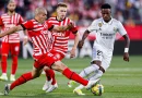 Girona and Real Madrid players jostling for possession