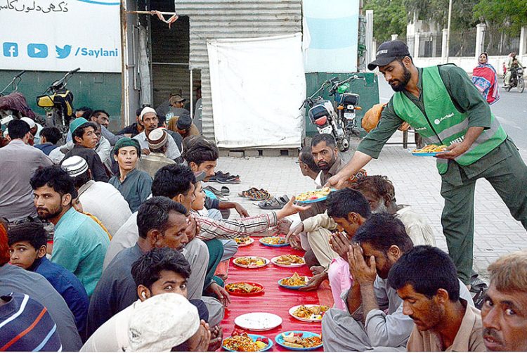 APP45-270323
KARACHI: March 27 - Volunteer distributing food among fasting people at an Iftar organized by Saylani Welfare at Numaish area. APP/SDQ/MOS