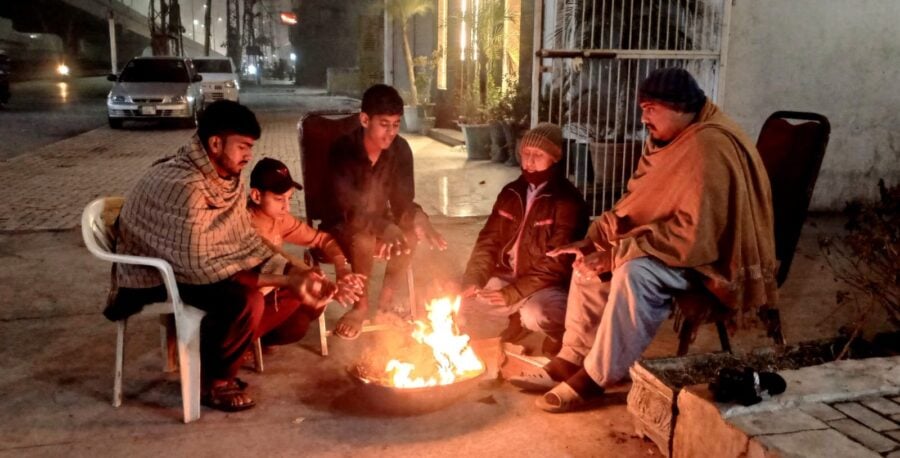 Citizens keeping their hands, bodies warm near fire amid freezing weather in Lahore